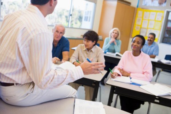 Mature students and their teacher in a classroom SONO APERTE LE ISCRIZIONI PER IL CORSO BABY SITTER